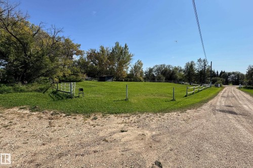 Expansive green lawn with mature trees and a partial wood rail fence - 3054 28 Avenue, Edmonton, AB 