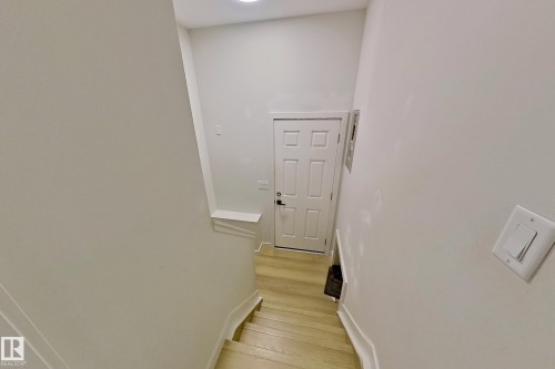 Staircase with light wood-finish treads and white risers - 3054 28 Avenue, Edmonton, AB 