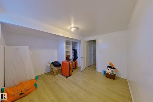 Room featuring wood-finish flooring, recessed lighting, white painted walls, and built-in closet storage with shelving - 3054 28 Avenue, Edmonton, AB 