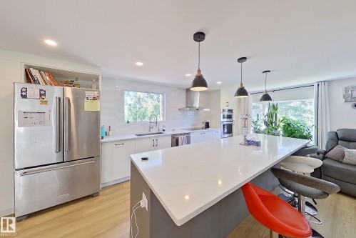 Expansive kitchen island with a light-toned countertop, complemented by modern pendant lighting - 3054 28 Avenue, Edmonton, AB 