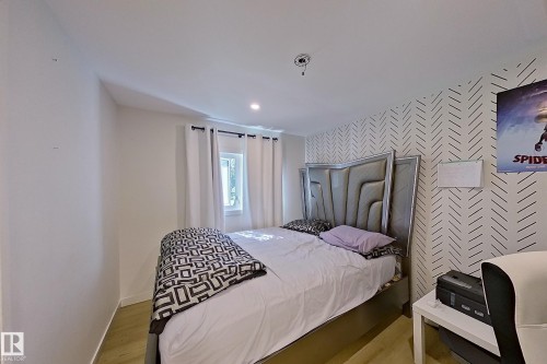 Bedroom featuring a window with white curtains, recessed lighting, and wood-finish flooring - 3054 28 Avenue, Edmonton, AB 
