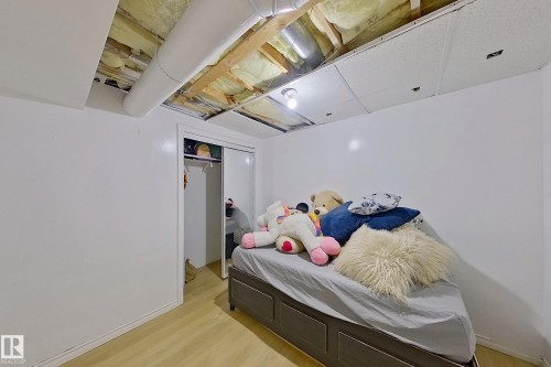 Room with light wood-finish flooring, white painted walls, and a sliding door closet - 3054 28 Avenue, Edmonton, AB 