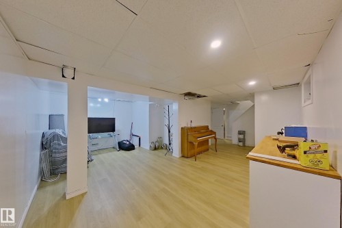 Open concept lower level featuring light wood-finish flooring, recessed lighting, and white painted walls - 3054 28 Avenue, Edmonton, AB 