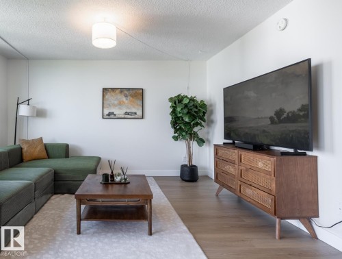 Bright living area featuring wood-finish flooring, crisp white walls, and a recessed ceiling light - 807 10011 116 Street, Edmonton, AB 