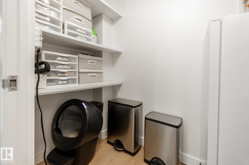 Utility closet featuring built-in shelving, light wood-finish flooring, and white wall finishes - 807 10011 116 Street, Edmonton, AB 