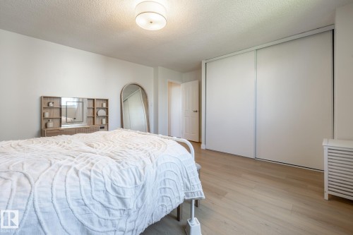 Light-toned wood-finish flooring complements the neutral wall palette - 807 10011 116 Street, Edmonton, AB 