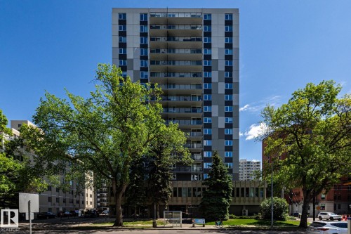Multi-story high-rise building featuring a patterned facade of grey and white panels, individual balconies, and a ground-level architectural base - 807 10011 116 Street, Edmonton, AB 