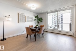 Bright dining area featuring new wood-finish flooring and a white wall finish - 