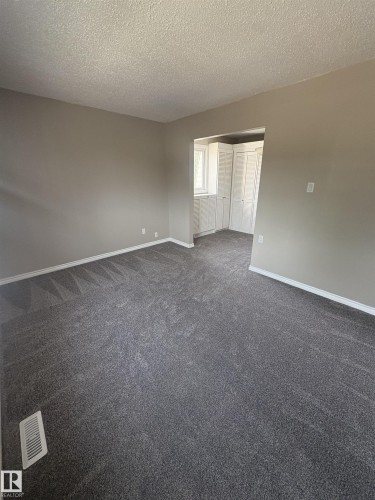 Spacious interior featuring fresh gray carpeting, neutral wall finishes, and clean white baseboards - 11 Greenfield Estates, St. Albert, AB 
