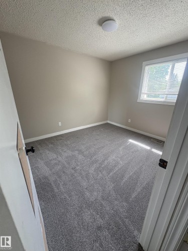 Room featuring new gray carpeting, neutral wall paint, white trim, and a window with blinds - 11 Greenfield Estates, St. Albert, AB 