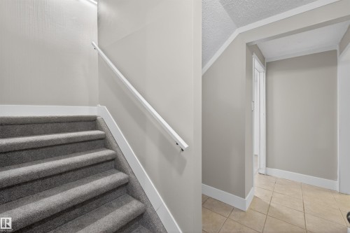 Staircase with gray carpeting and a white handrail, complemented by light gray walls and white trim - 11 Greenfield Estates, St. Albert, AB 