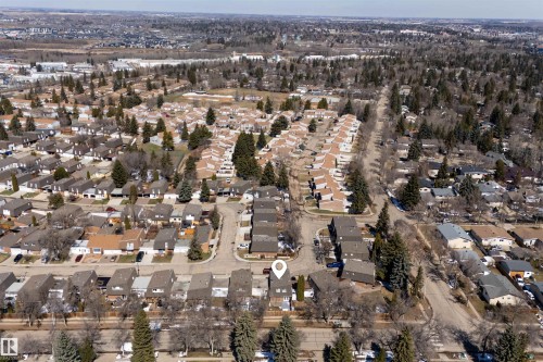 Aerial perspective showcasing a residential neighborhood with diverse housing styles, mature trees, and a network of streets - 11 Greenfield Estates, St. Albert, AB 