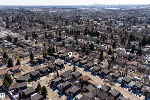 Residential neighborhood with established tree cover and distant city skyline visible - 11 Greenfield Estates, St. Albert, AB 