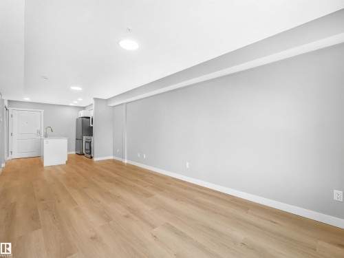 Expansive main living area featuring light wood-finish flooring, light gray walls, and recessed ceiling lighting - 318 1506 Tamarack Boulevard, Edmonton, AB 