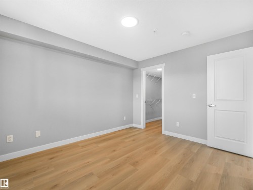 Room featuring light wood-finish flooring, light gray walls, and white trim - 318 1506 Tamarack Boulevard, Edmonton, AB 