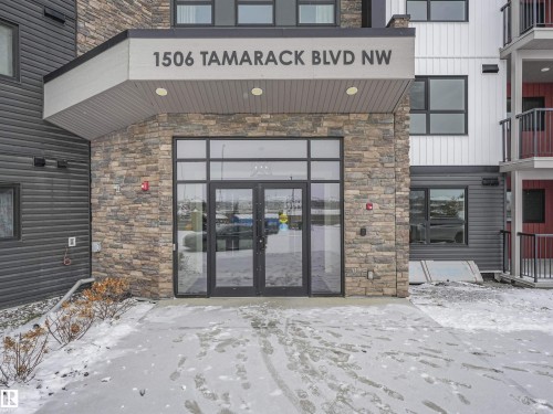 Building entrance featuring stone veneer and dark siding - 318 1506 Tamarack Boulevard, Edmonton, AB 