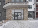 Building entrance featuring stone veneer and dark siding - 318 1506 Tamarack Boulevard, Edmonton, AB 
