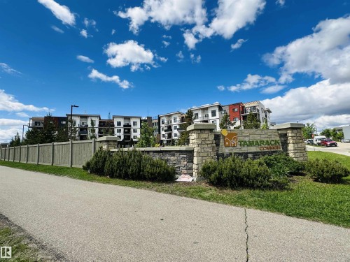 Tamarack Common stone monument sign with integrated landscaping and a paved pathway - 318 1506 Tamarack Boulevard, Edmonton, AB 