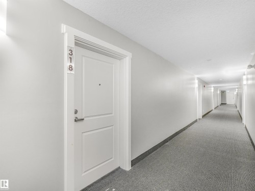 Entry door with paneled design and brushed nickel hardware - 318 1506 Tamarack Boulevard, Edmonton, AB 