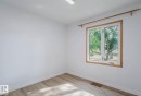 Room featuring light wood-finish flooring, white walls, and a window with wood trim - 10948 75 Avenue, Edmonton, AB 