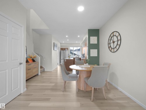 Open-concept dining area featuring wood-finish flooring, recessed lighting, and a sightline to the kitchen - 5022 Kinney Link Sw, Edmonton, AB 