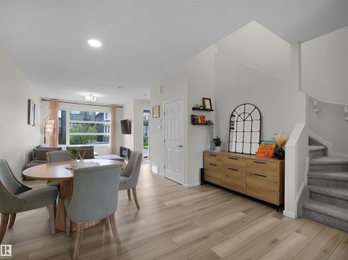 Open-concept living area featuring light wood-finish flooring, recessed lighting, and a prominent window - 5022 Kinney Link Sw, Edmonton, AB 