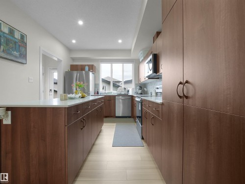 Modern kitchen featuring wood-finish cabinetry, light-toned countertops, and recessed lighting - 5022 Kinney Link Sw, Edmonton, AB 