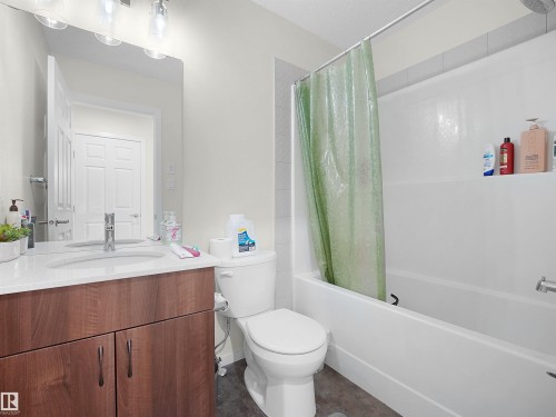 Bathroom featuring a wood-finish vanity with a white countertop and undermount sink - 5022 Kinney Link Sw, Edmonton, AB 