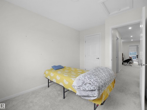 Carpeted room with a white door, light-colored walls, and a ceiling access panel - 5022 Kinney Link Sw, Edmonton, AB 
