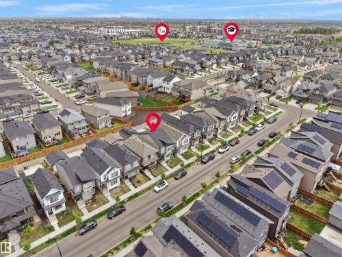 Residential community featuring detached and semi-detached homes, paved streets, and visible solar panel installations on several rooftops - 5022 Kinney Link Sw, Edmonton, AB 