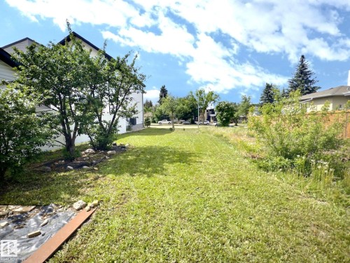 Expansive grass lawn with mature trees and a partial wood fence - 9551 85 Street, Edmonton, AB 