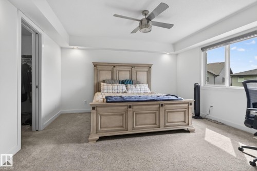 Carpeted room featuring a ceiling fan, recessed lighting, and a large window - 704 39 Street, Edmonton, AB 