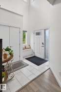 Bright entry featuring a white paneled door with frosted glass and a smart lock - 
