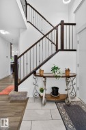 Grand staircase featuring dark wood newel posts and handrails with iron balusters - 