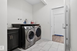 Utility room featuring white tile flooring and white walls - 
