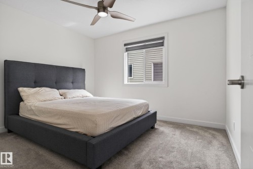 Bright room featuring neutral carpeting and a modern ceiling fan - 704 39 Street, Edmonton, AB 