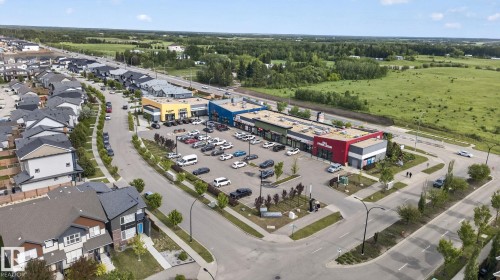 Retail plaza featuring multiple storefronts with distinct colorful facades, ample surface parking, and direct road frontage - 704 39 Street, Edmonton, AB 