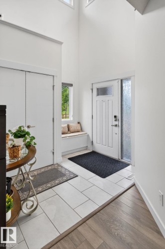 Bright entryway featuring a white paneled front door, transom window, and adjacent sidelight with textured glass - 704 39 Street, Edmonton, AB 