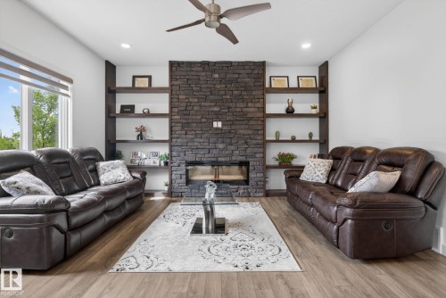 Living area featuring a floor-to-ceiling stacked stone fireplace with an integrated linear firebox - 704 39 Street, Edmonton, AB 