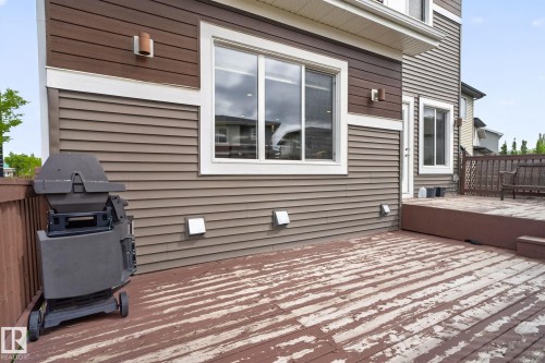 Spacious outdoor deck with a brown railing, featuring a multi-level design and a siding exterior - 704 39 Street, Edmonton, AB 
