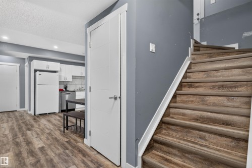 Wood-finish stairs with white trim and a contrasting gray wall - 704 39 Street, Edmonton, AB 