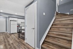 Wood-finish stairs with white trim and a contrasting gray wall - 