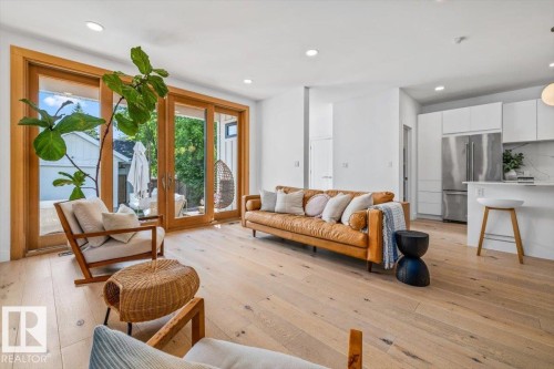 Spacious interior featuring wide-plank wood-finish flooring, recessed lighting, and white walls - 10641 126 Street, Edmonton, AB 