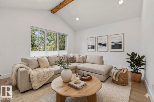 Vaulted ceiling with exposed wood beam, recessed lighting, wood-finish flooring, and large multi-pane windows - 10641 126 Street, Edmonton, AB 