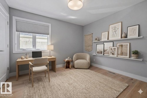 Light-filled room featuring wood-finish flooring, a window with blinds, and white baseboards - 10641 126 Street, Edmonton, AB 