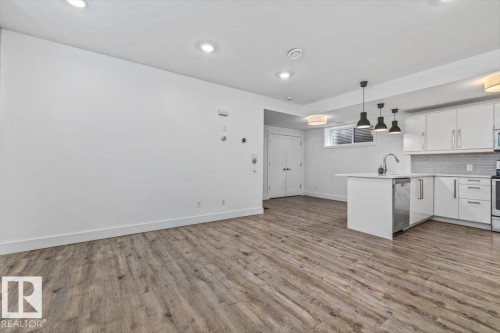 Open-concept living area featuring wood-finish flooring and recessed lighting - 10641 126 Street, Edmonton, AB 
