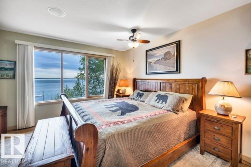 Vaulted wood-plank ceiling with expansive windows showcasing the backdrop of your lakefront setting - 275 Poplar Crescent, Rural Wetaskiwin County, AB - Indoor Photo Showing Living Room With Fireplace