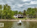Stone paver patio featuring a built-in fire pit, surrounded by decorative rock landscaping perfect for winding up your fun filled day on the water! - 275 Poplar Crescent, Rural Wetaskiwin County, AB  - Outdoor With Deck Patio Veranda 