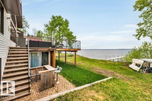 Vaulted ceiling lined with wood  and the expansive windows showcase the sparkling waters of Pigeon Lake - 275 Poplar Crescent, Rural Wetaskiwin County, AB - Indoor