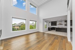 Expansive living area featuring soaring ceilings and wood-finish flooring - 
